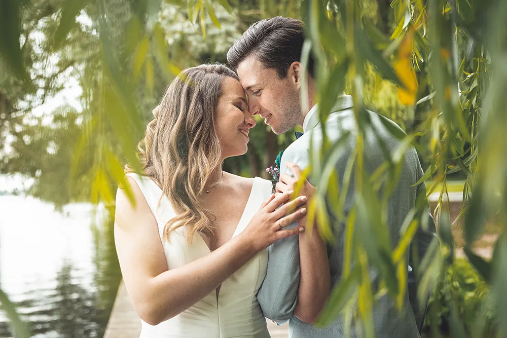 Braut und Bräutigam umgeben von einer Weide - Mirja John Hochzeitsfotografie
