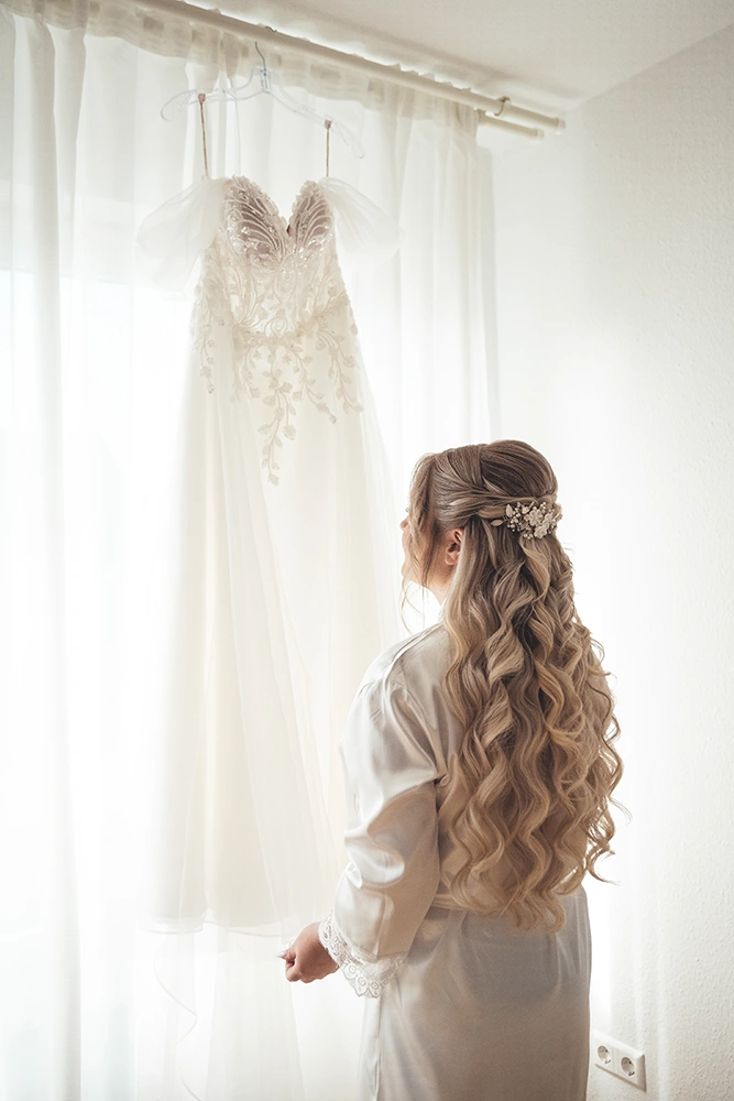 Braut guckt sich ihr Brautkleid an - Mirja John Hochzeitsfotografie